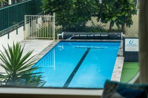 a view of a swimming pool from a window at Oceanside Marine Pde Magic in Mount Maunganui