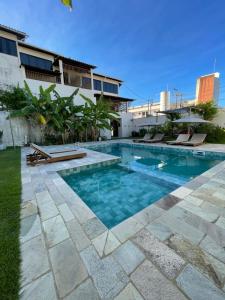 a swimming pool in front of a building at Pousada Laranja - Nova Administração in Natal