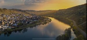 ein Fluss mit einer Gruppe von Häusern und einer Stadt in der Unterkunft Ferienhaus Ausonius in Neumagen-Dhron