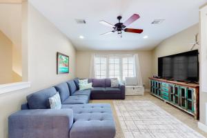 a living room with a blue couch and a tv at Barefoot Bungalo in Destin