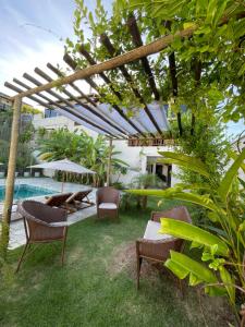 un patio con sillas, mesas y una piscina en Pousada Laranja - Nova Administração en Natal