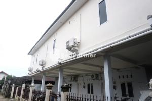 a white building with a fence in front of it at Tassa Homestay Syariah Mitra RedDoorz in Jambi