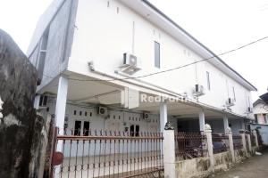 a white building with a fence in front of it at Tassa Homestay Syariah Mitra RedDoorz in Jambi