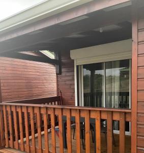 a porch with a wooden railing on a house at Depaysement total au coeur de la campagne de vacances ideales pour se ressourcer in Saint-Louis