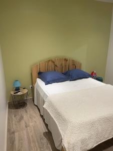 een slaapkamer met een groot bed met een houten hoofdeinde bij Depaysement total au coeur de la campagne de vacances ideales pour se ressourcer in Saint-Louis