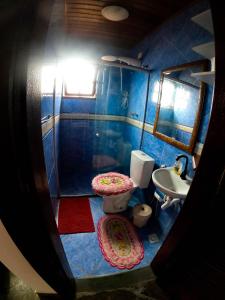 a blue bathroom with a toilet and a sink at Pousada Relíquias do Mar in Arraial do Cabo