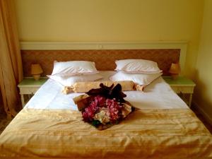 a bed with a bouquet of flowers on it at Complex La Tunuri - Vila Economat in Sinaia