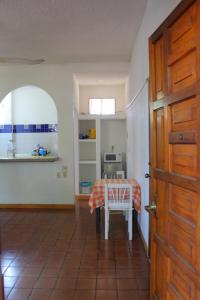 Habitación con mesa, mesa y puerta en Hotel Albatros, en Puerto Escondido