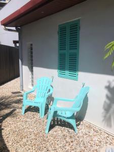 twee blauwe stoelen buiten een huis bij The Hideway in Noumea