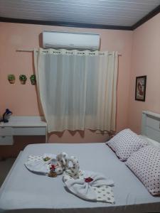 Un dormitorio con una cama y una ventana con toallas. en Vista da Guarita, en Torres