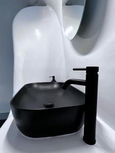 un lavabo negro sentado en un mostrador en un baño en Oinos Luxury Suites Caldera, en Oia