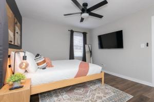 a bedroom with a bed and a ceiling fan at 3 Mi to City & Pet Friendly & Quiet Neighborhood in Charlotte