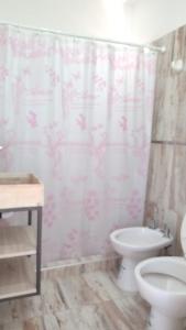 a bathroom with a toilet and a shower curtain at Depto para 4 personas in San Antonio Oeste