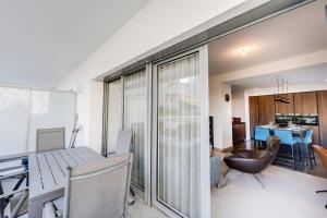 a kitchen and dining room with a table and chairs at L'Envolée - Charming T2 with terrace air conditioning in Annecy