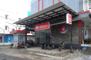 a group of motorcycles parked in front of a store at RedDoorz near Taman Pantai Alam Indah Tegal in Tegal
