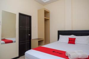 Dormitorio pequeño con cama y armario en RedDoorz near Taman Pantai Alam Indah Tegal, en Tegal