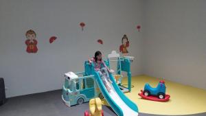 a girl on a slide in a room with toys at iSanook Resort & Suites Hua Hin in Hua Hin