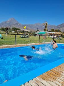 een paar mensen zwemmen in een zwembad bij Cabaña 1 vista campana in Hijuelas