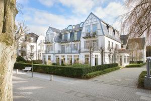 a large white building with windows on a street at Aparthotel Kühlungsborn, Villa am Konzertgarten in Kühlungsborn