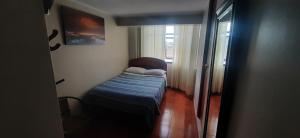 a small bed in a room with a window at HOSTAL SAMAYWASI in Huancayo