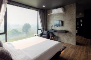 The View Chiang Dao Hotel في تشينغ داو: غرفة فندقية بسرير ونافذة كبيرة