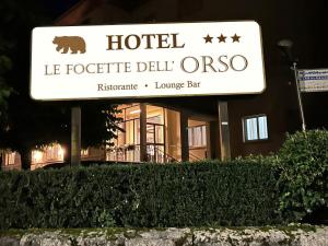una señal para un hotel frente a un edificio en Le Focette dell'Orso, en Scanno