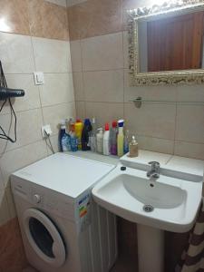 a bathroom with a sink and a washing machine at Beach House in Kissamos