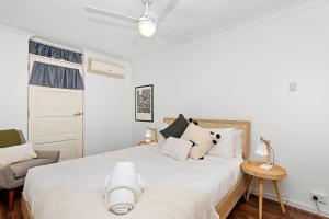 um quarto branco com 2 camas e uma cadeira em 22 Heavenly Highgate New 2br Parkinghbf em Perth