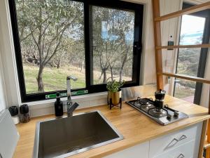 a kitchen with a sink and two large windows at Moonbah Escapez in Moonbah