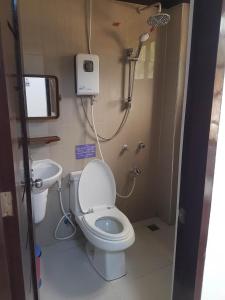 a small bathroom with a toilet and a sink at JACE'S Travelers Inn in El Nido