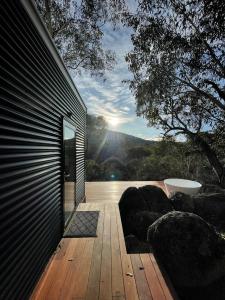 une terrasse en bois avec vue sur la montagne dans l'établissement Moonbah Escapez, à Moonbah