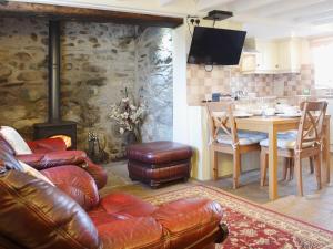a living room with a couch and a table and a kitchen at Cyll Y Felin Fawr 1 in Aberdaron