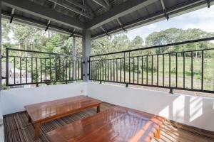 une terrasse couverte avec un banc en bois sur un balcon dans l'établissement Erika Homestay, à Lembang