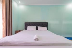 a large white bed with a white towel on it at Erika Homestay in Lembang