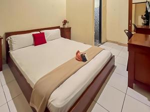 a bedroom with a large bed with a camera on it at Akavi Homestay Jayapura Redpartner in Jayapura