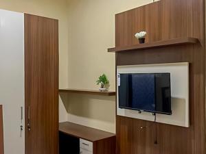 Akavi Homestay Jayapura Redpartner في جايابورا: غرفة معيشة مع تلفزيون بشاشة مسطحة في غرفة