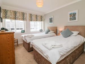 2 camas en una habitación con 2 ventanas en Crab Cottage, en Ilfracombe