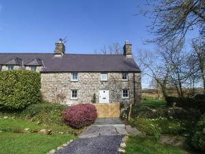 una vecchia casa in pietra con vialetto di Y Bwthyn Ty Du a Llannor