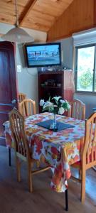 a dining room table with a floral table cloth on it at Cabaña 1 lagunillas in Navidad