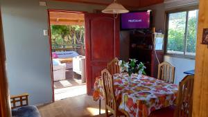 a dining room with a table and a television in a room at Cabaña 1 lagunillas in Navidad