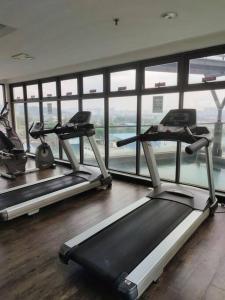 einem Fitnessraum mit drei Laufbändern vor einem Fenster in der Unterkunft Urban360 studio lovely with Netflix and Wi-Fi in Batu Caves