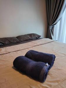 ein Bett mit einem blauen Handtuch darüber in der Unterkunft Urban360 studio lovely with Netflix and Wi-Fi in Batu Caves