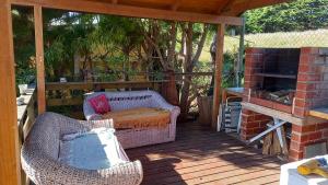 a patio with two chairs and a fireplace on a deck at Cabaña 1 lagunillas in Navidad