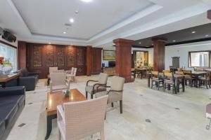 a lobby with tables and chairs and a restaurant at Urbanview Hotel Taman Suci Denpasar Bali in Denpasar