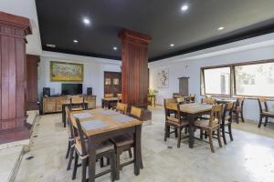 a dining room with wooden tables and chairs at Urbanview Hotel Taman Suci Denpasar Bali in Denpasar