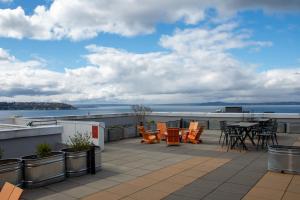 eine Terrasse mit Stühlen und Tischen auf dem Dach in der Unterkunft Chic Queen Anne Retreat in Seattle