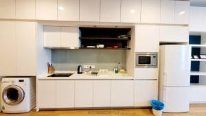 a kitchen with white cabinets and a refrigerator at The Platinum KLCC in Kuala Lumpur +66 photos
