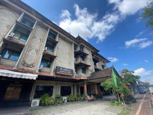 a building on a street with a blue sky at Urbanview Hotel Taman Suci Denpasar Bali in Denpasar