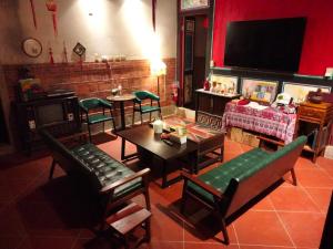 a living room with a table and chairs and a tv at 作客七號 in Jincheng