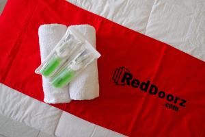 a pair of white towels and a toy on a bed at RedDoorz Syariah near Taman Rekreasi Kalianget Wonosobo in Kalianget